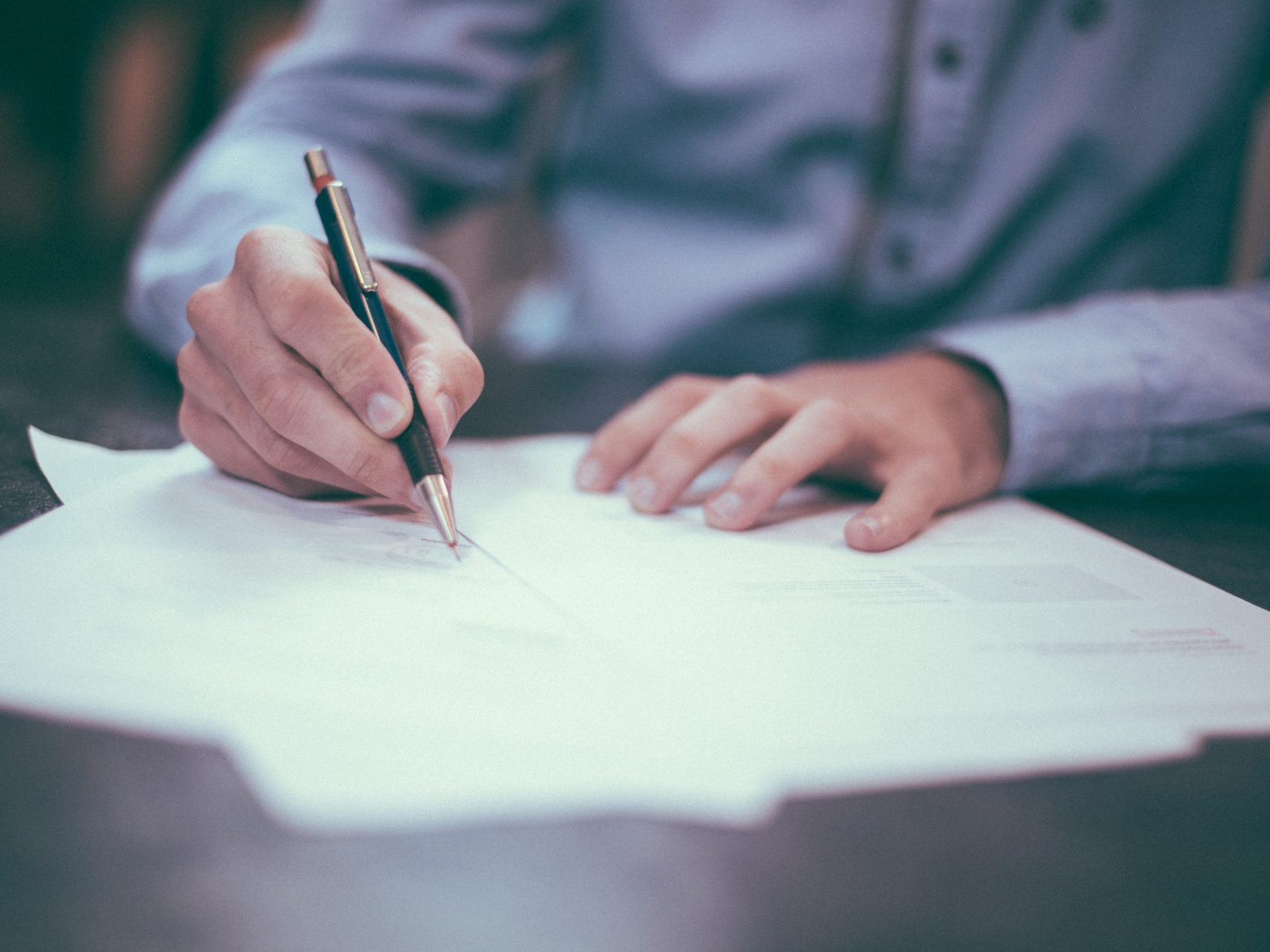 man writing on paper